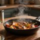 A steaming skillet of chicken and vegetables surrounded by rice, beans, and sauce.