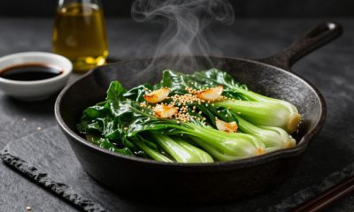 Sautéed baby bok choy with garlic and sesame in a cast-iron skillet.